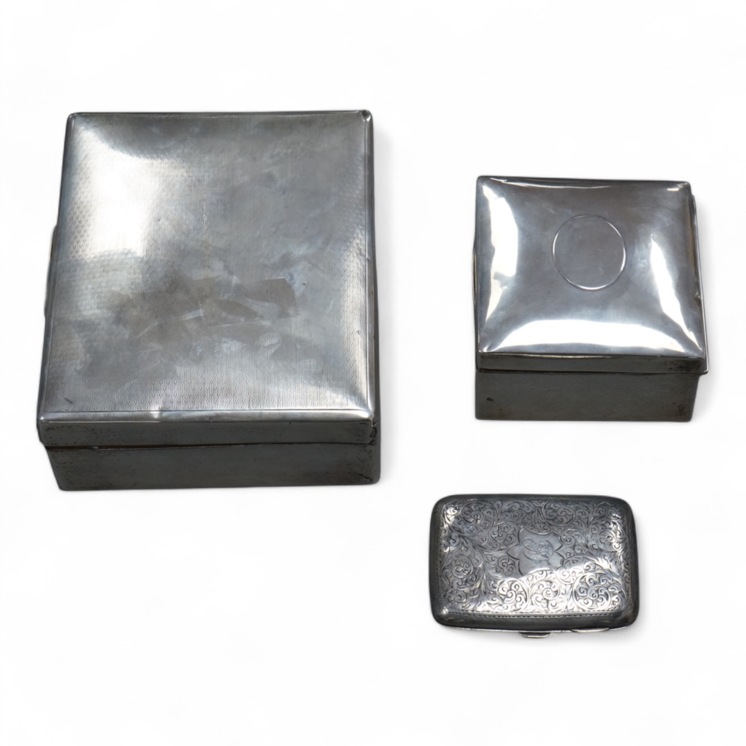 A George V silver mounted rectangular cigarette box, London, 1924, width 16cm, together with a smaller silver mounted cigarette box and a silver cigarette case.